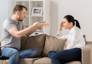 couple arguing sitting on sofa stages of a narcissistic relationship with an empath