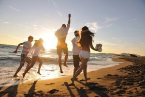 Friends having fun on a summer beach during sunset.